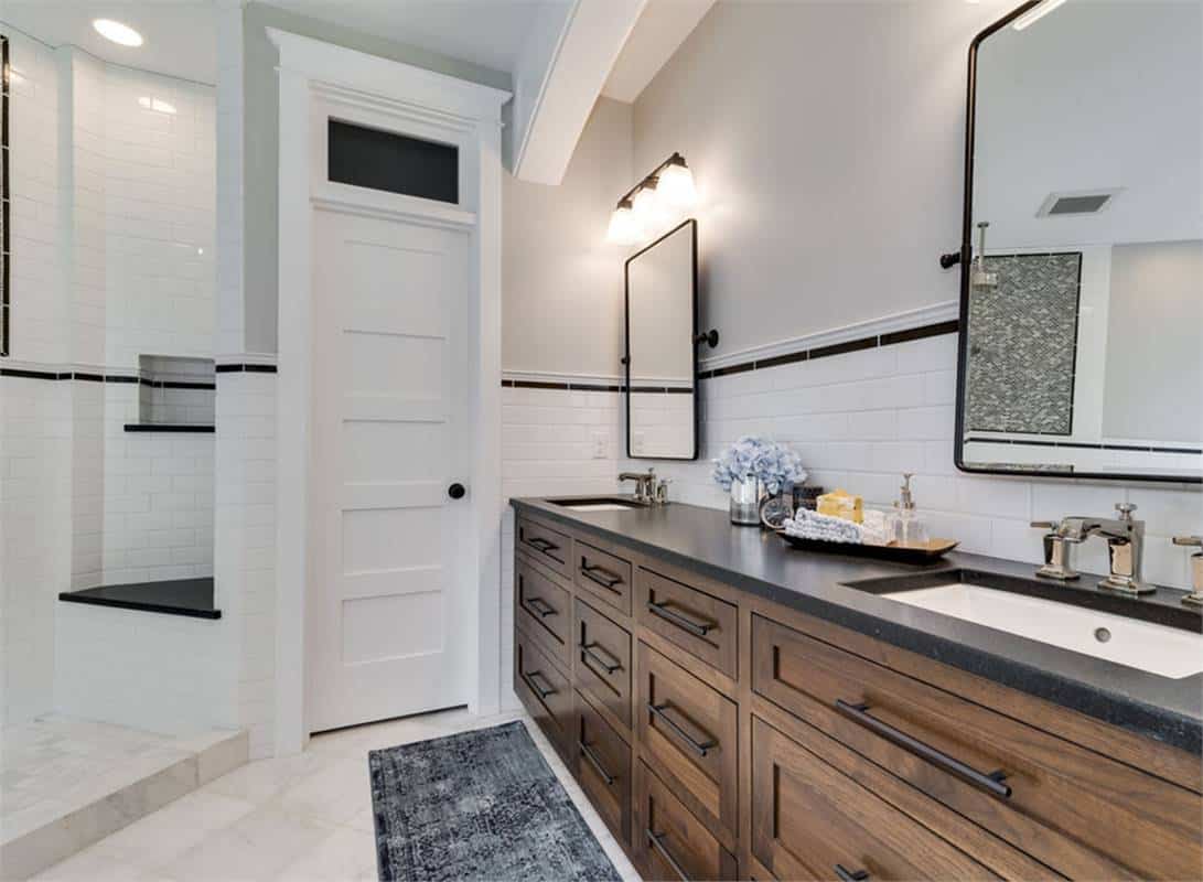 Primary vanity with two sinks, dark wood cabinets, and framed mirrors.