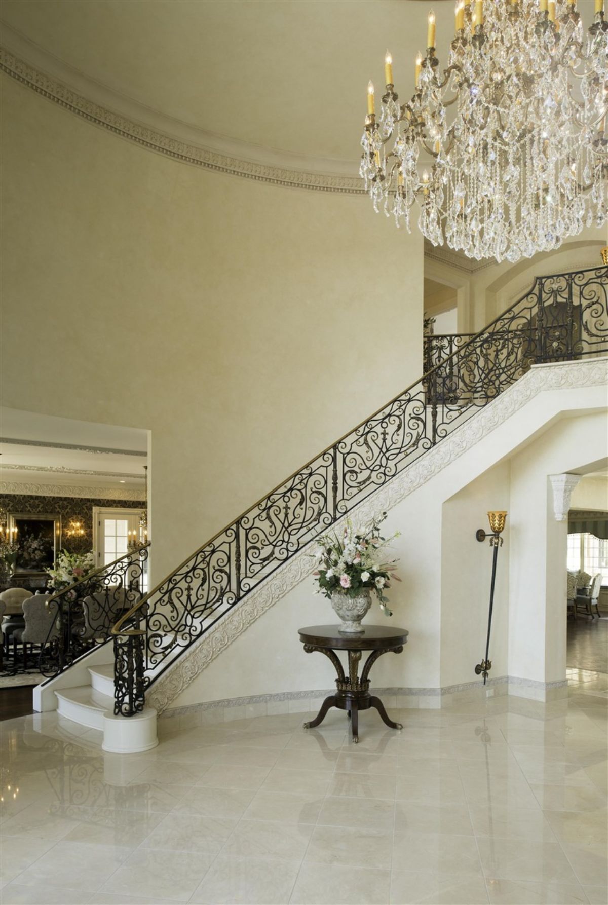 An entryway table, stairs and chandelier in the entrance hall.