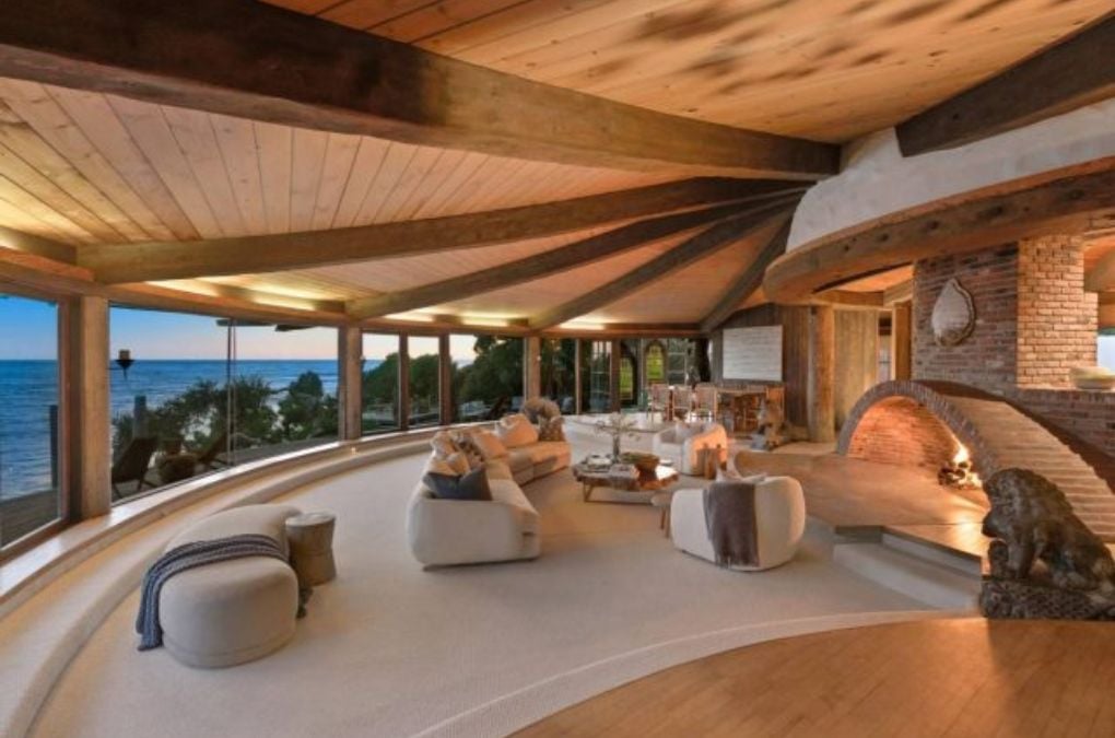 A living room with a fireplace made of bricks.