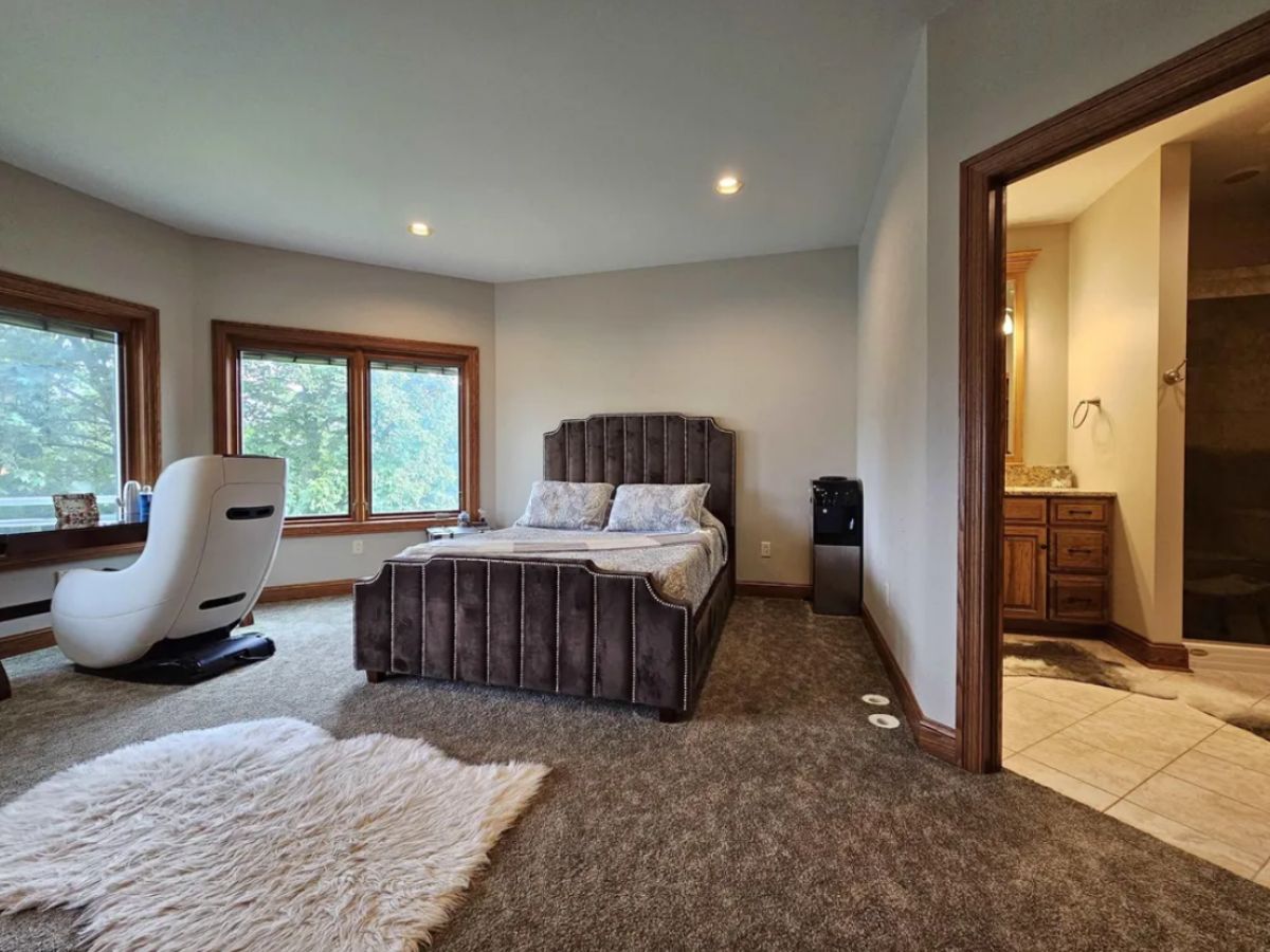 Bedroom with carpet flooring, custom lighting, and glass windows.