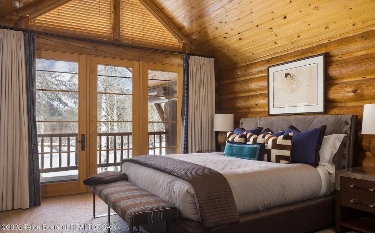 Bedroom with carpet flooring, glass doors, and a wooden wall.