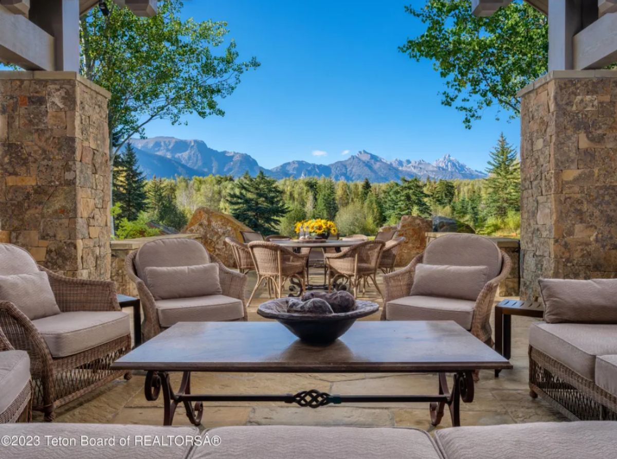 Patio with tables, chairs, and a view of the mountains.