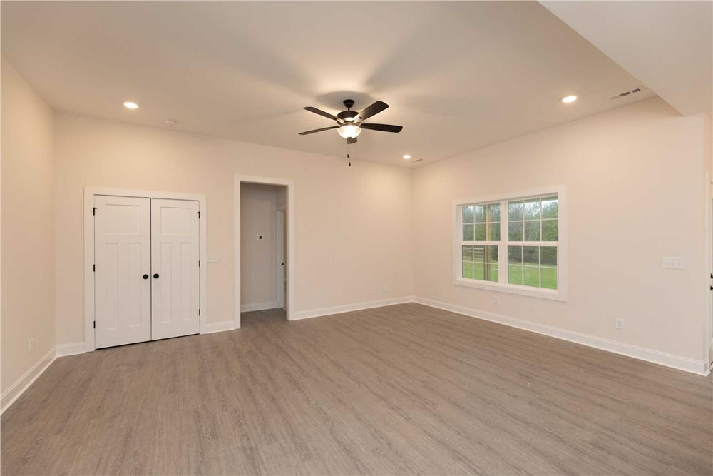 Family room with beige walls and hardwood flooring.