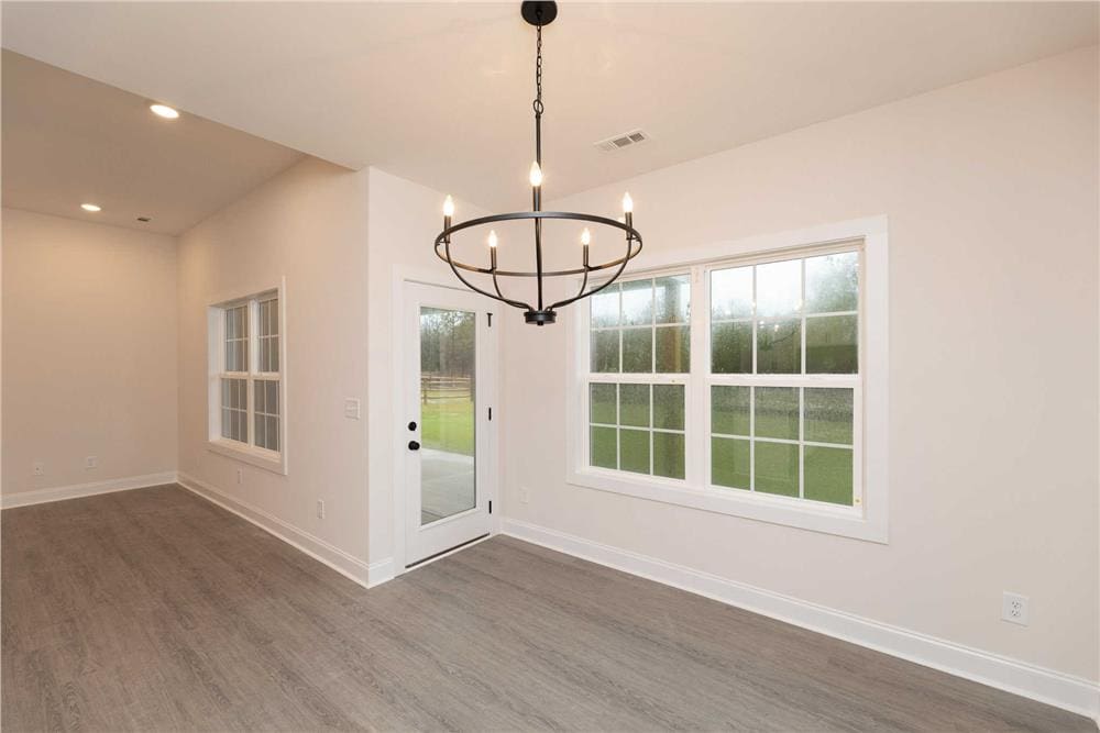 Dining area with a wrought iron chandelier and a glazed door that opens to the rear patio.
