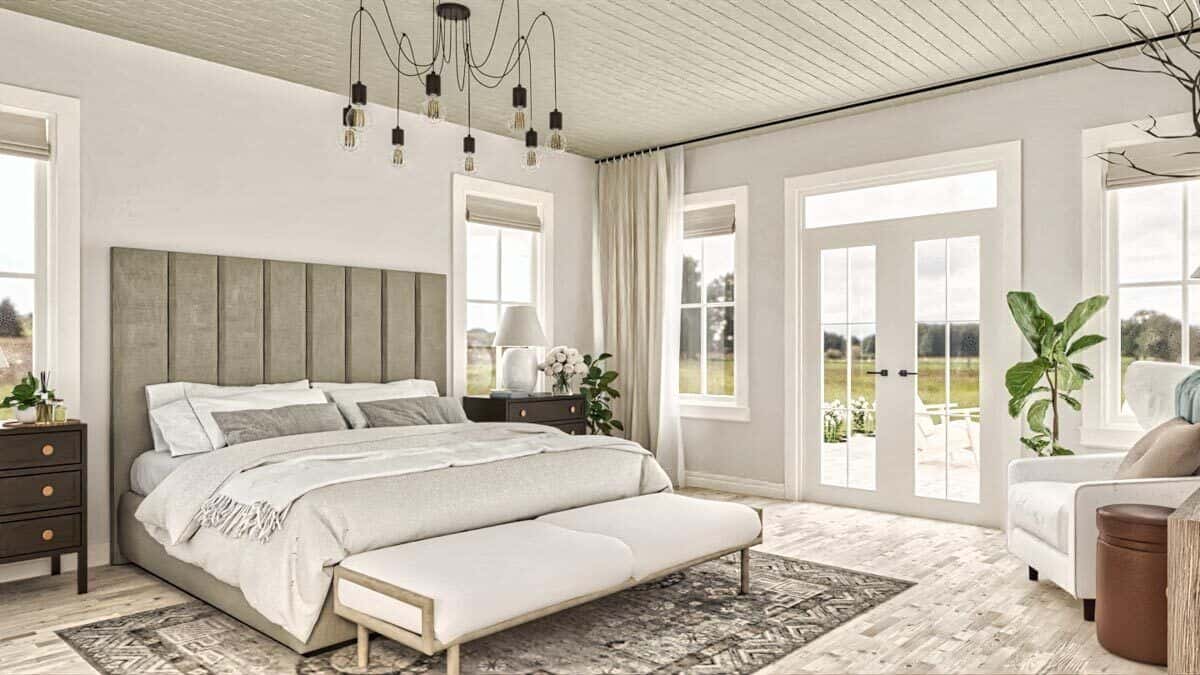 Primary bedroom with an upholstered bed, a cushioned bench, and a French door that opens to the rear deck.
