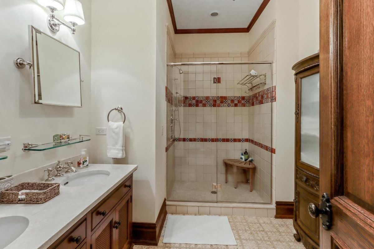 Bathroom with a sink, tile flooring, and a shower.