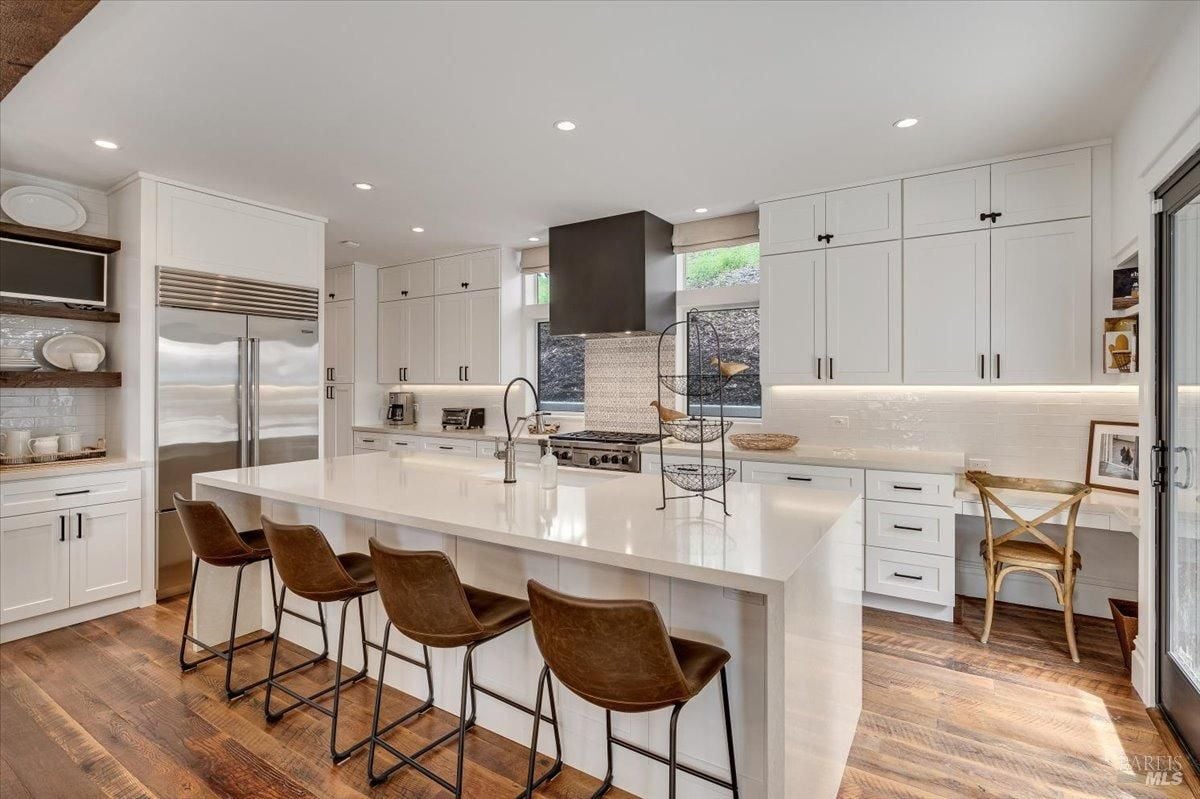 Kitchen with custom cabinets, custom cabinets and wood flooring.