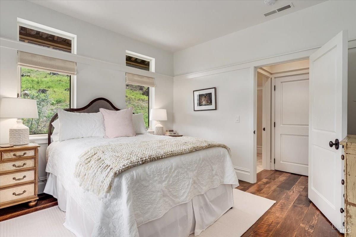 Bedroom with a large bed and wood flooring.