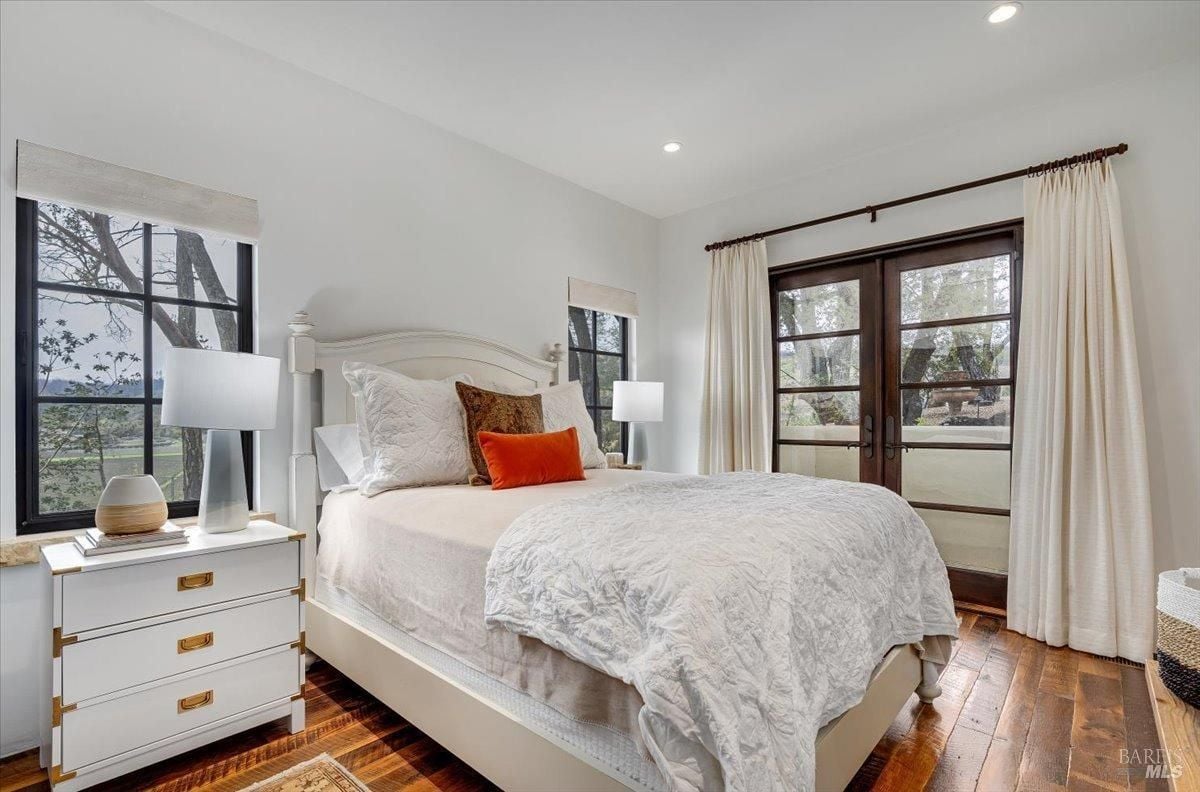 Bedroom with wood flooring and glass windows.