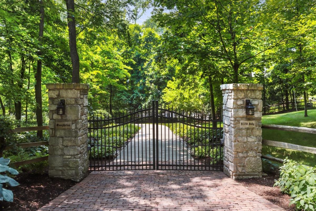 Gate with a spacious driveway and brick walkway.