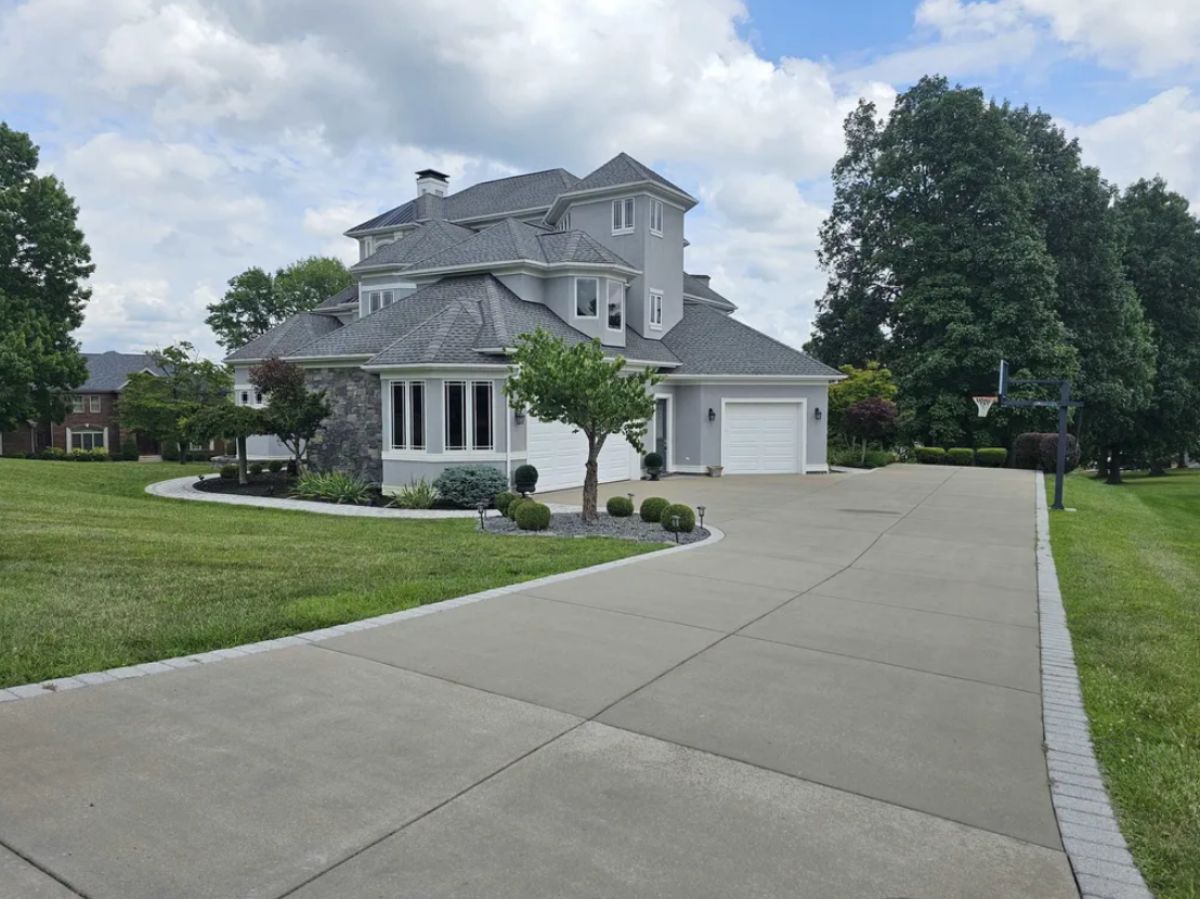 Front view of the house with garages and a large driveway.