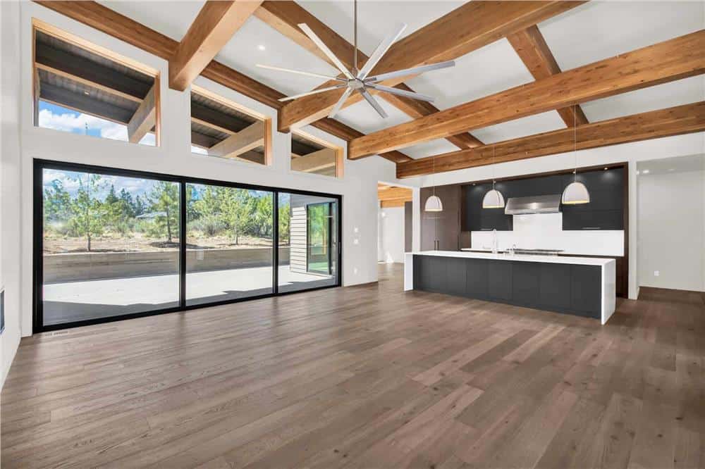Great room and kitchen with hardwood flooring and oversized sliding glass doors that open onto the back porch.