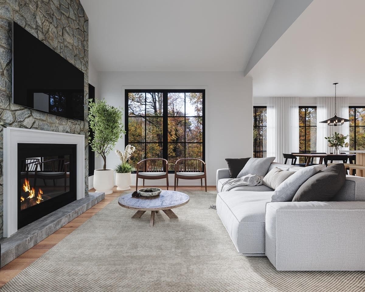 Living room with a gray sofa, round-back chairs, and an electric fireplace topped with a TV.