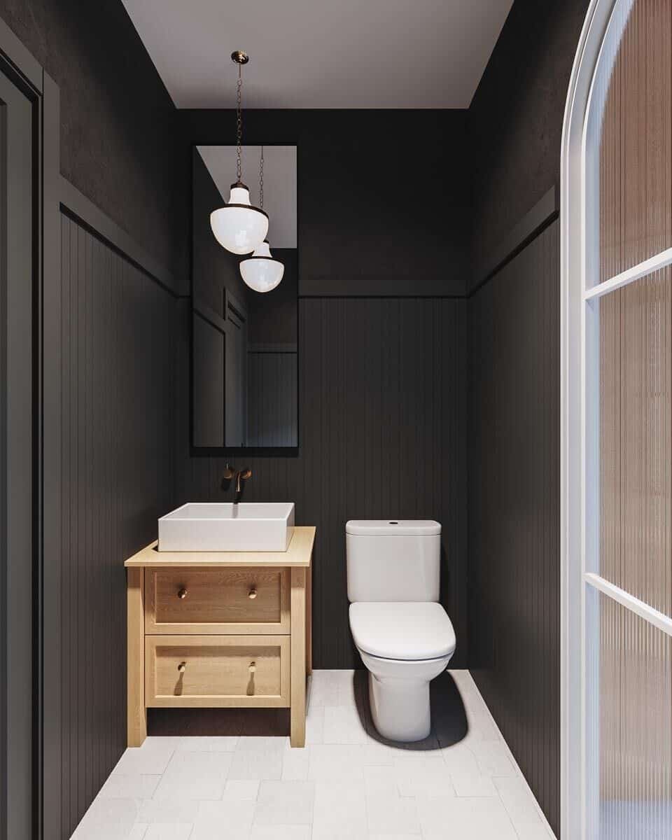 Powder room with a vessel sink and a toilet surrounded by black walls.