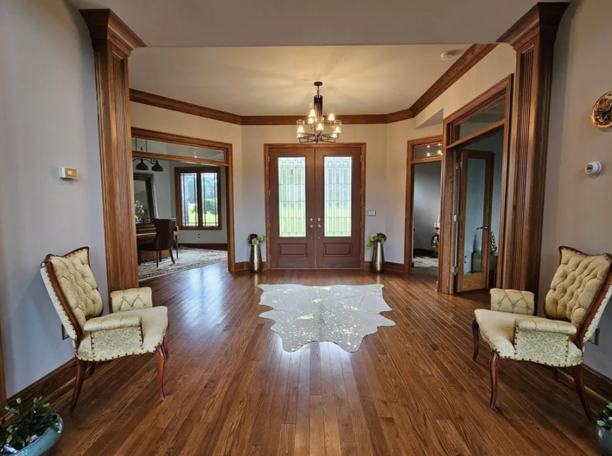 Foyer with wooden floors and a chandelier.