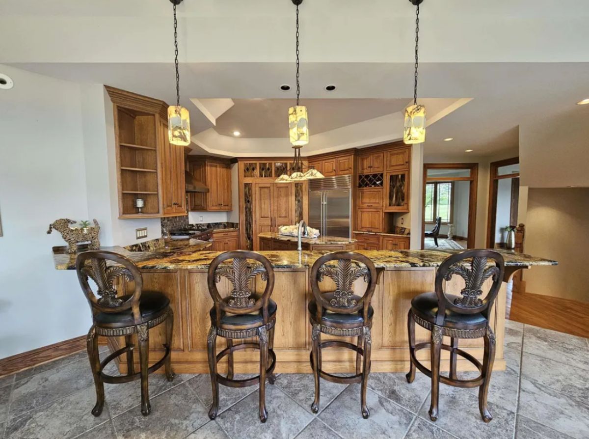 Kitchen with custom lighting, magma granite counter, breakfast bar, and high-end cabinets.