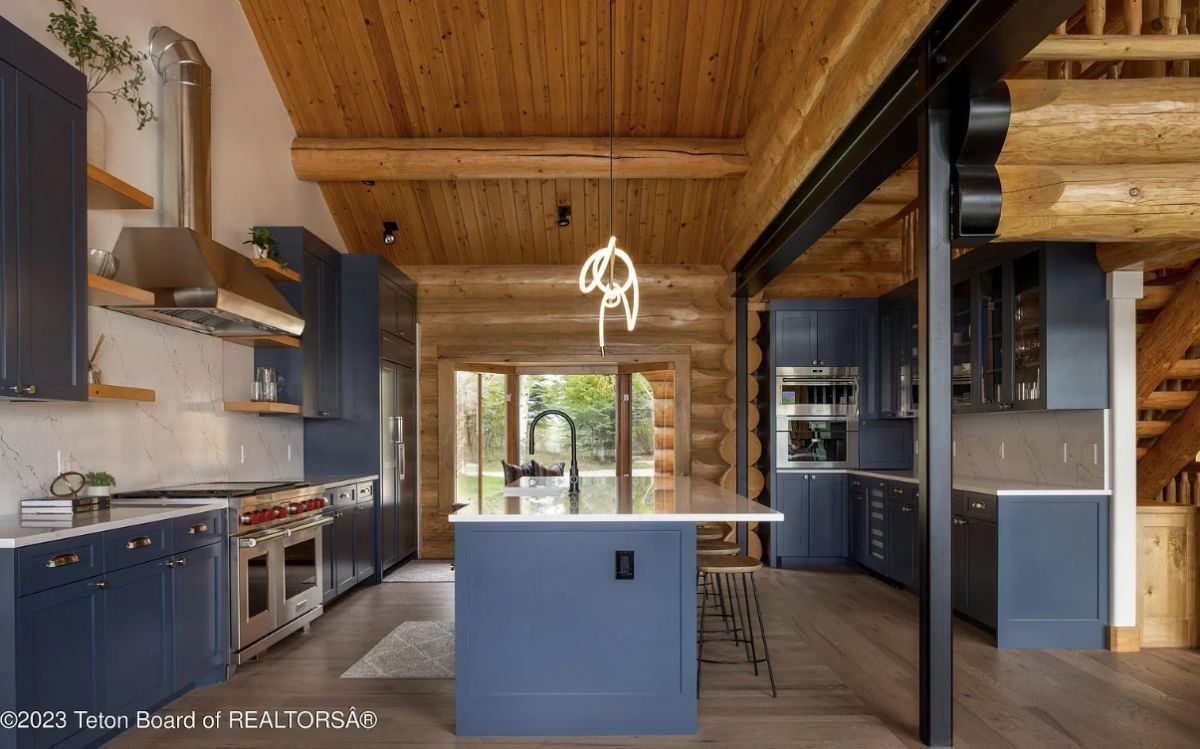 Kitchen with blue cabinets. new high-end appliances, and wooden ceiling.