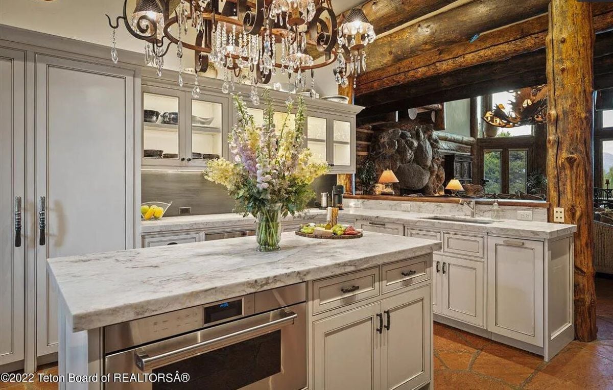 Kitchen with a chandelier, custom cabinetry, and a large island.