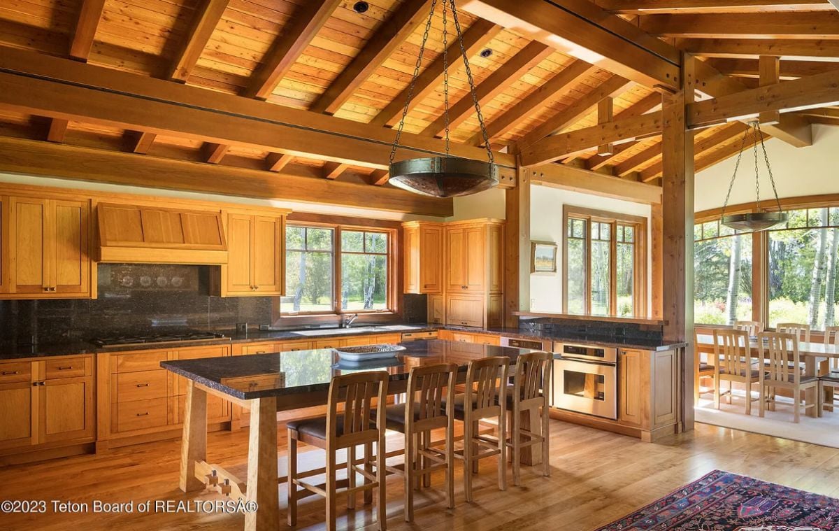 Kitchen with vaulted ceiling, wood flooring, wooden cabinets and a large island.
