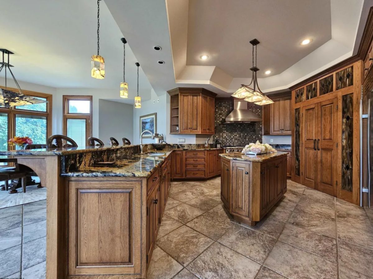 Kitchen with custom lighting, magma granite counter, breakfast bar, and tile flooring.