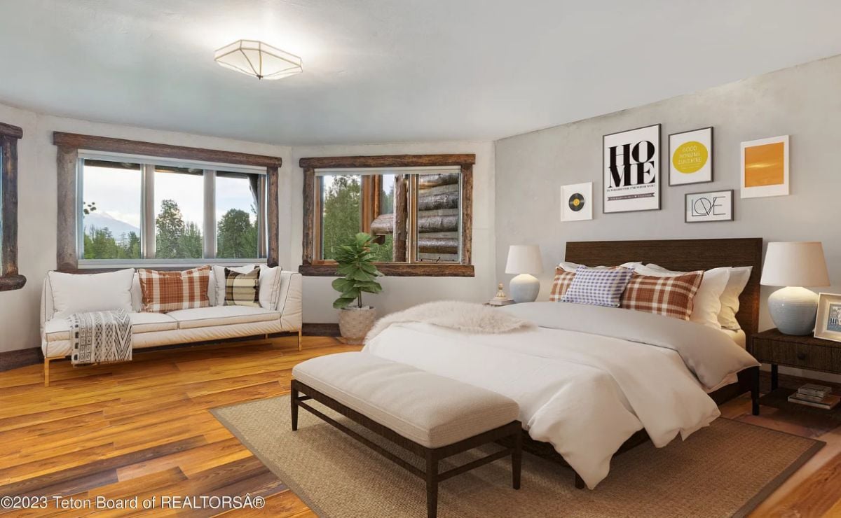 Bedroom with wooden floors, a large rug, and glass windows.