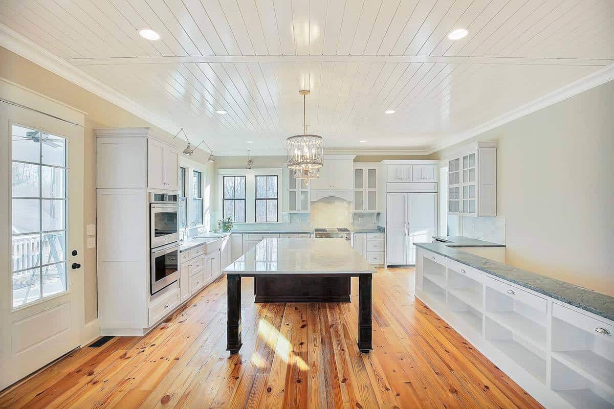 Kitchen with ample storage, double-wall ovens, and a center island topped with a drum chandelier.
