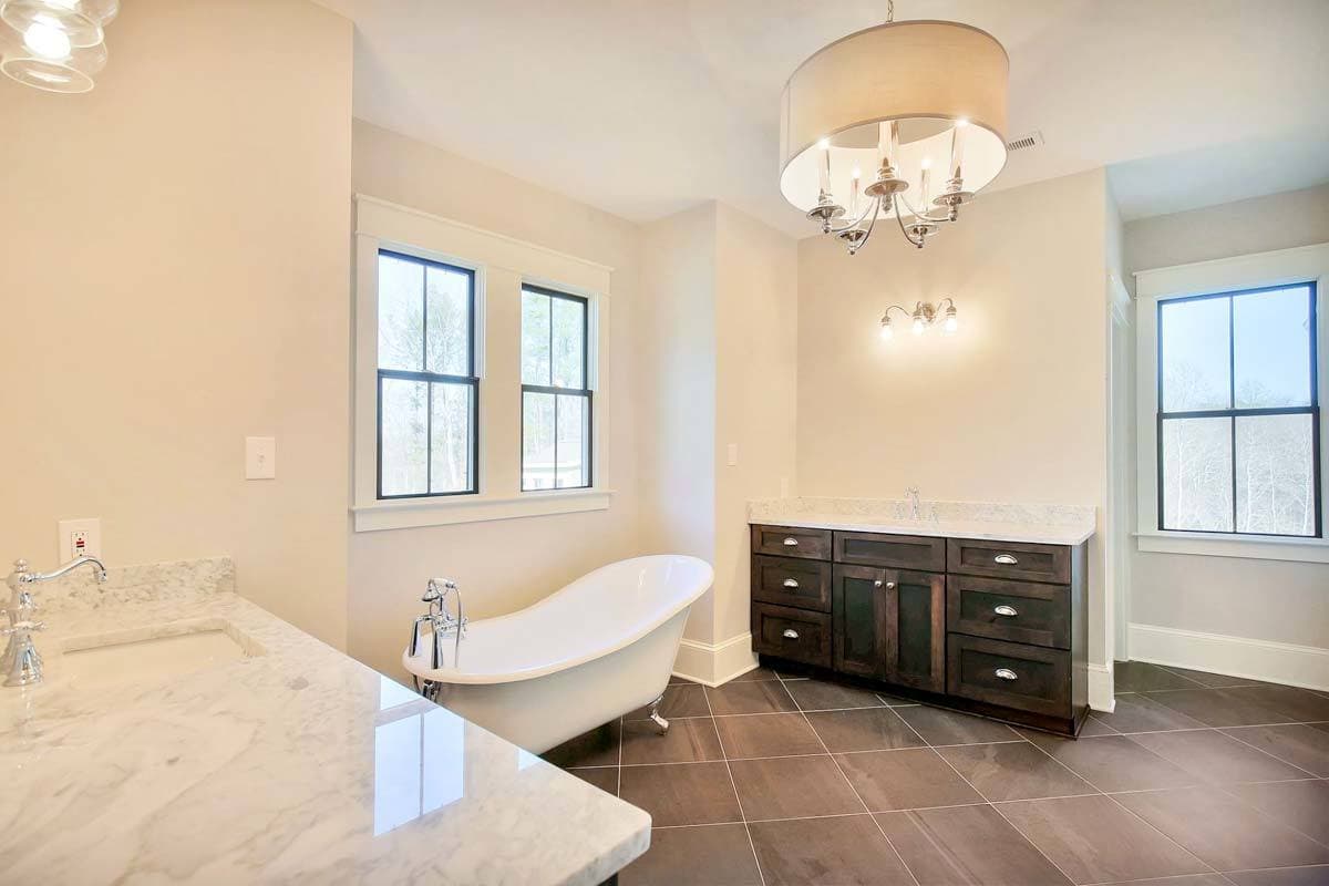 Primary bathroom with his and her vanities flanking the clawfoot tub.