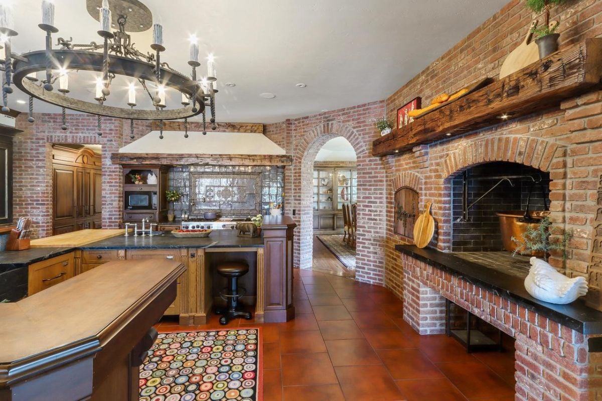 Kitchen with custom cabinetry, brick walls and a large oven.