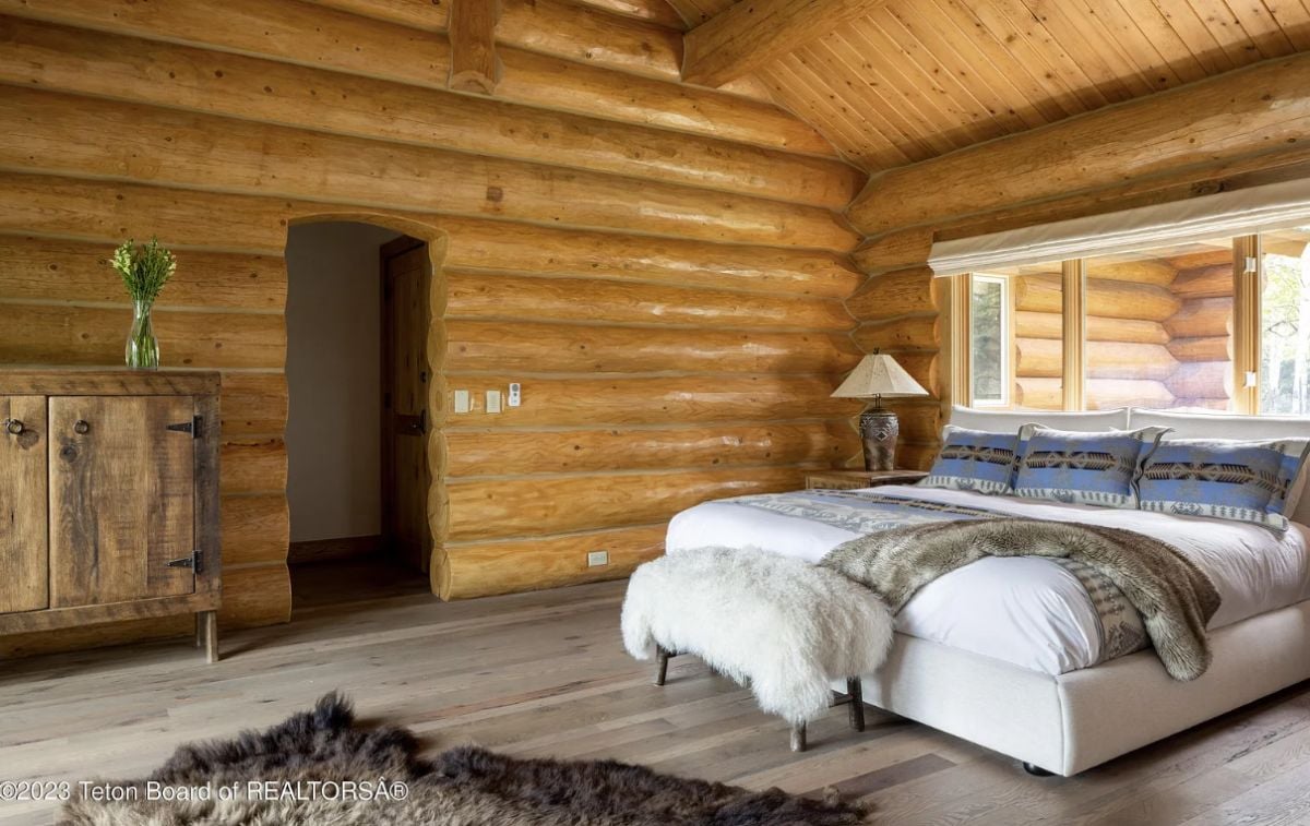 Bedroom with wooden walls and a large bed.