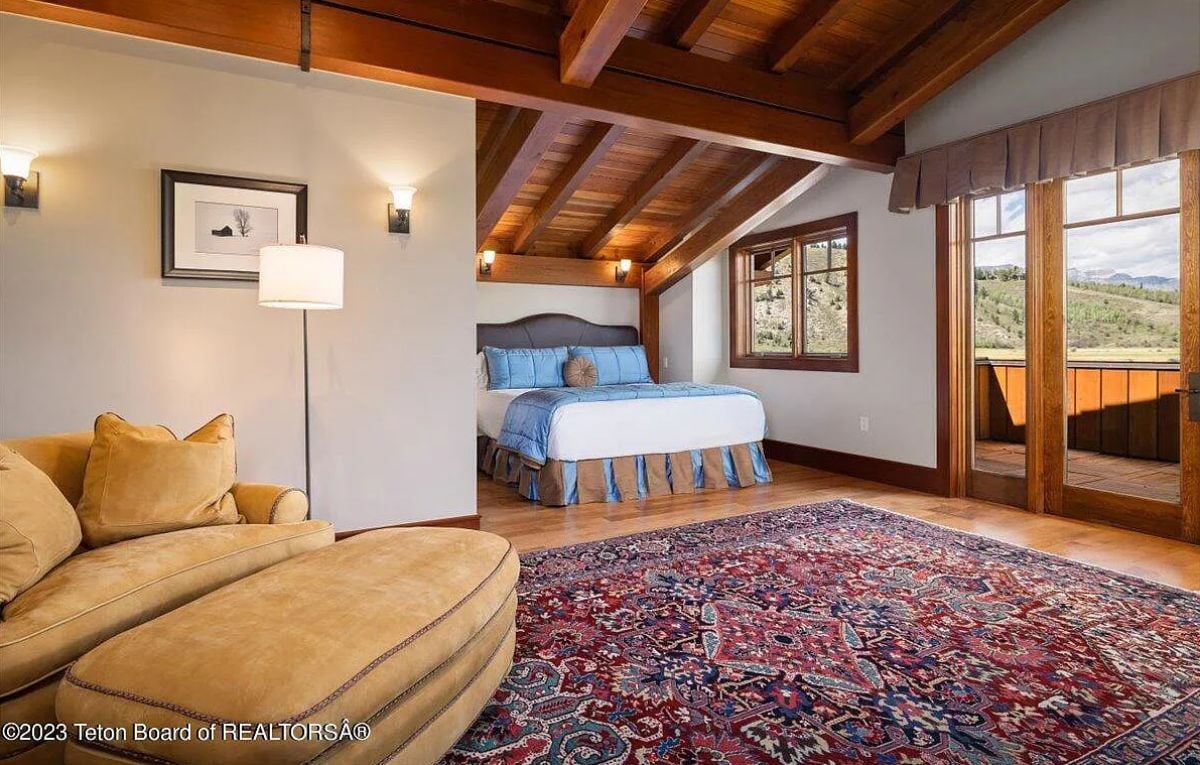 Bedroom with wooden floors, custom lighting and glass doors.