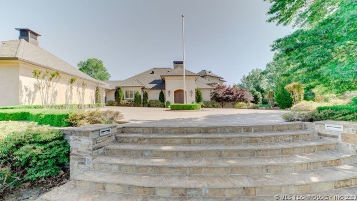 Front view of the mansion and a flag pole.