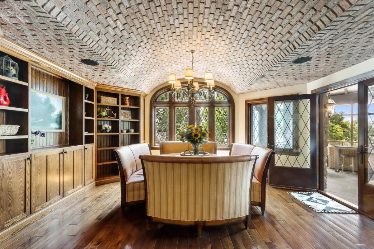 Breakfast area with a wooden floor, glass doors, and a chandelier.