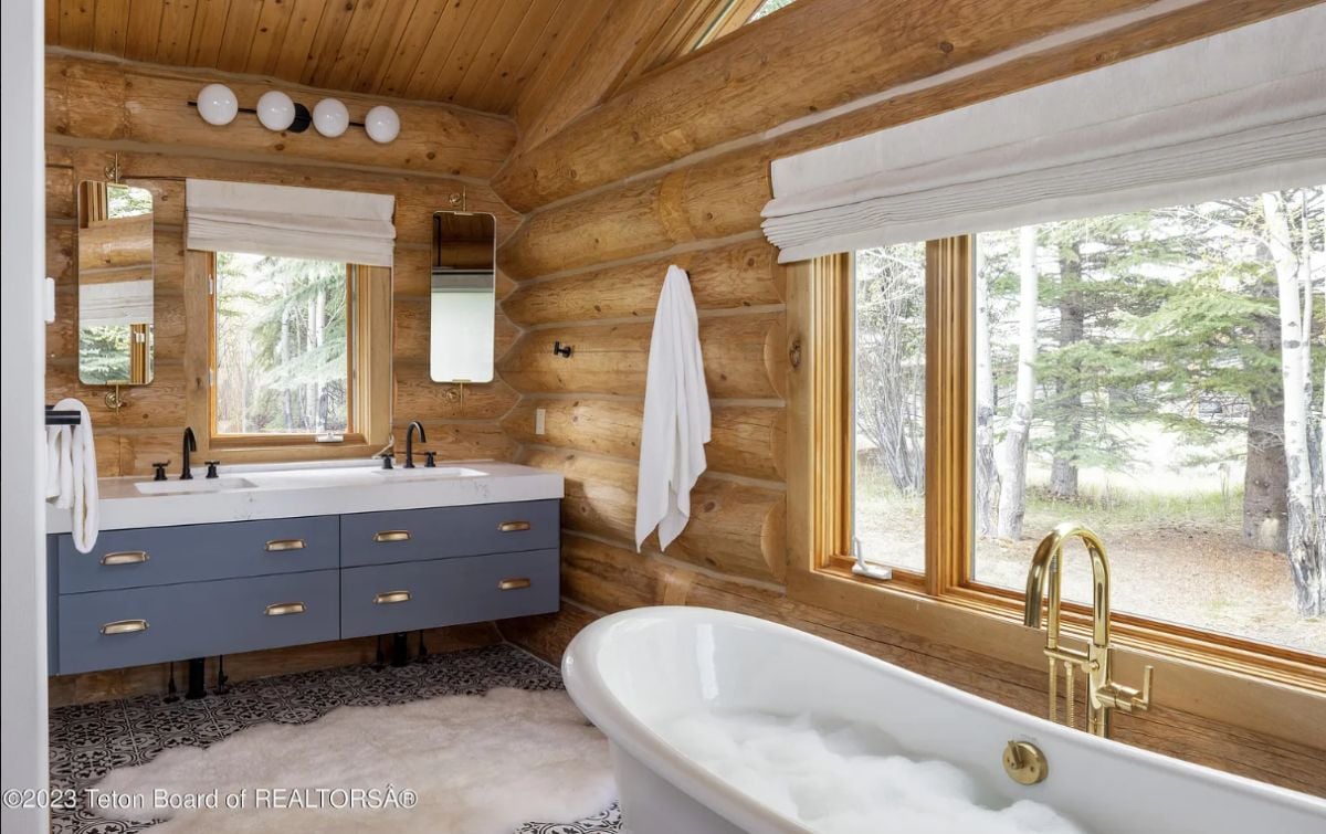 Bathroom with sinks, a soaking tub, and glass windows.