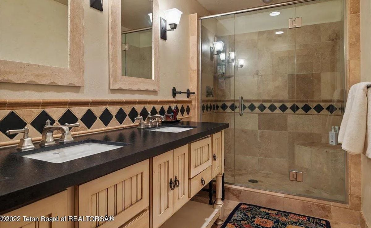 Bathroom with sinks, custom lighting and a shower.