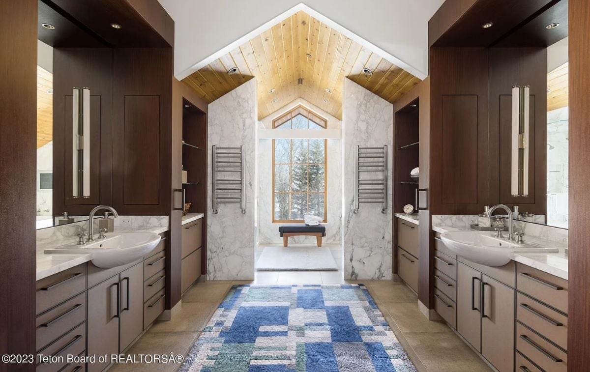 Bathroom with sinks, custom cabinetry, and custom lighting.
