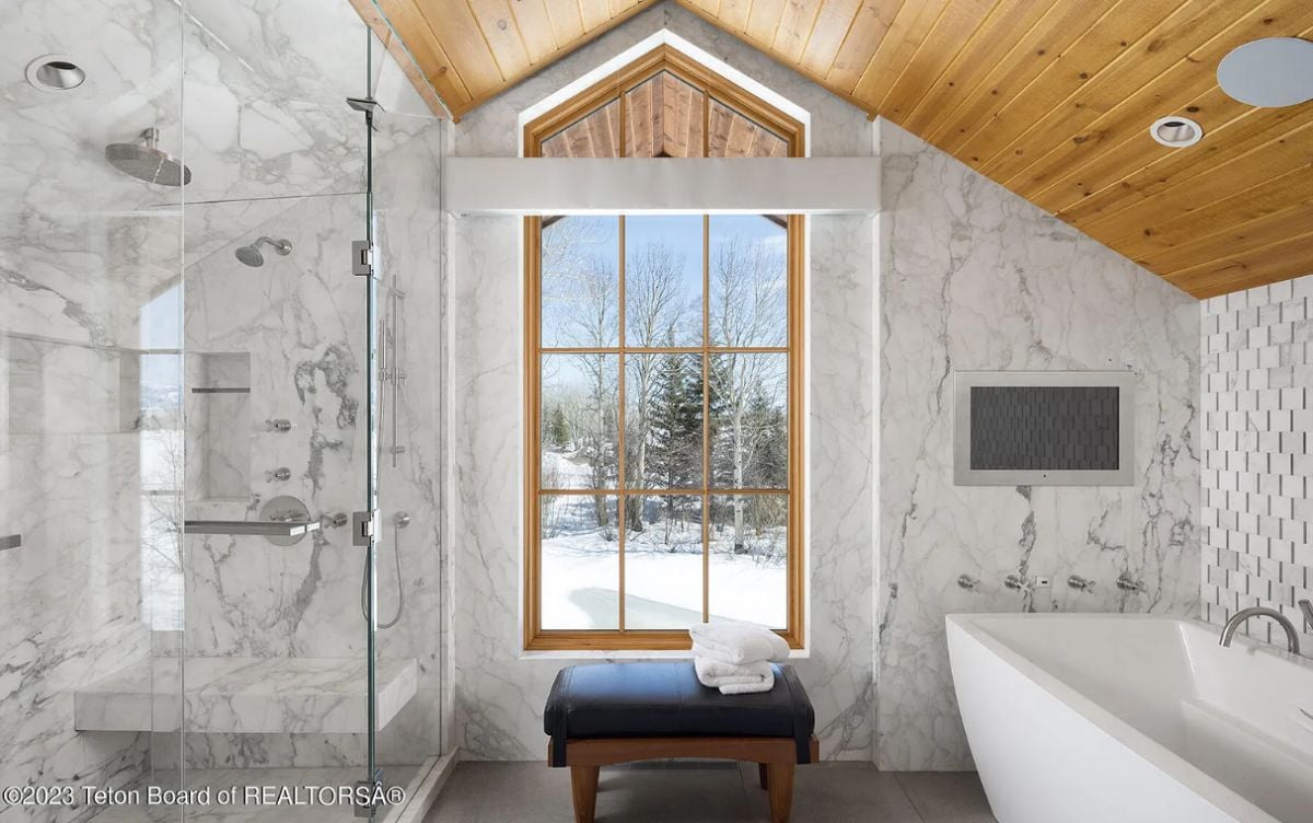 Bathroom with a shower, a soaking tub, and glass windows.