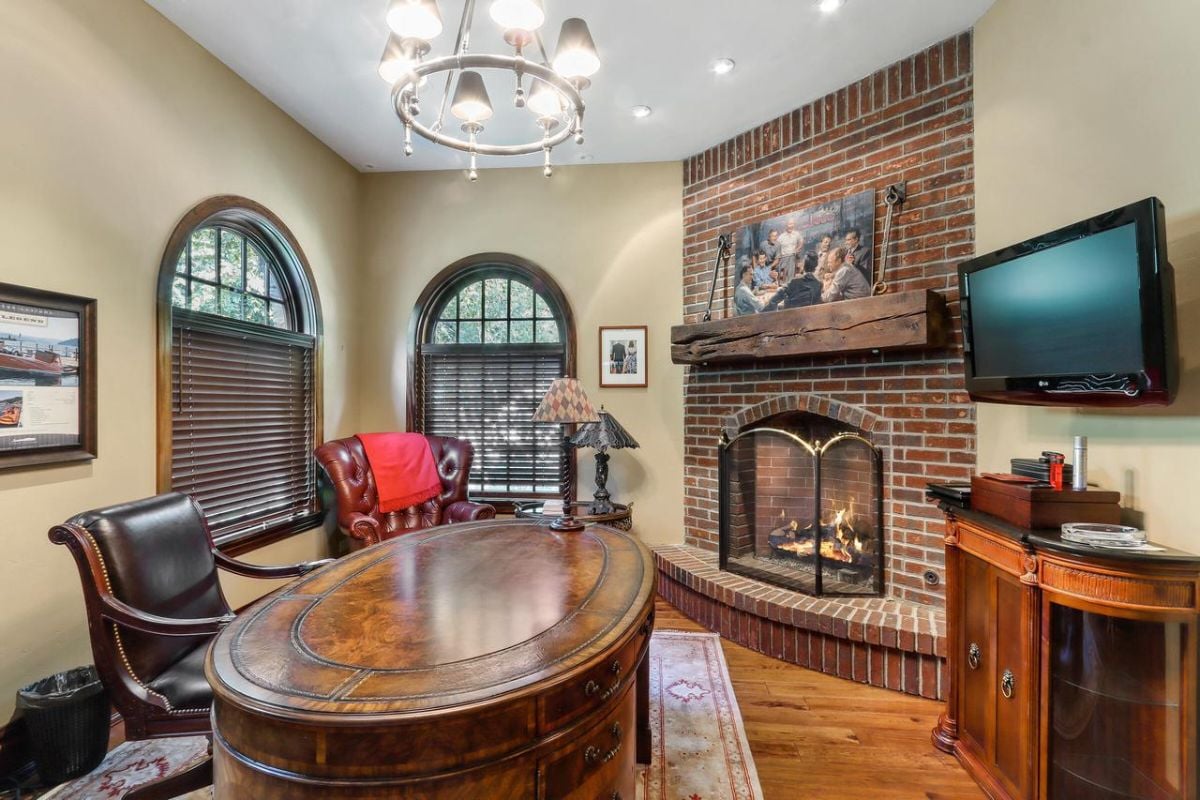 Home office with a fireplace and a TV.