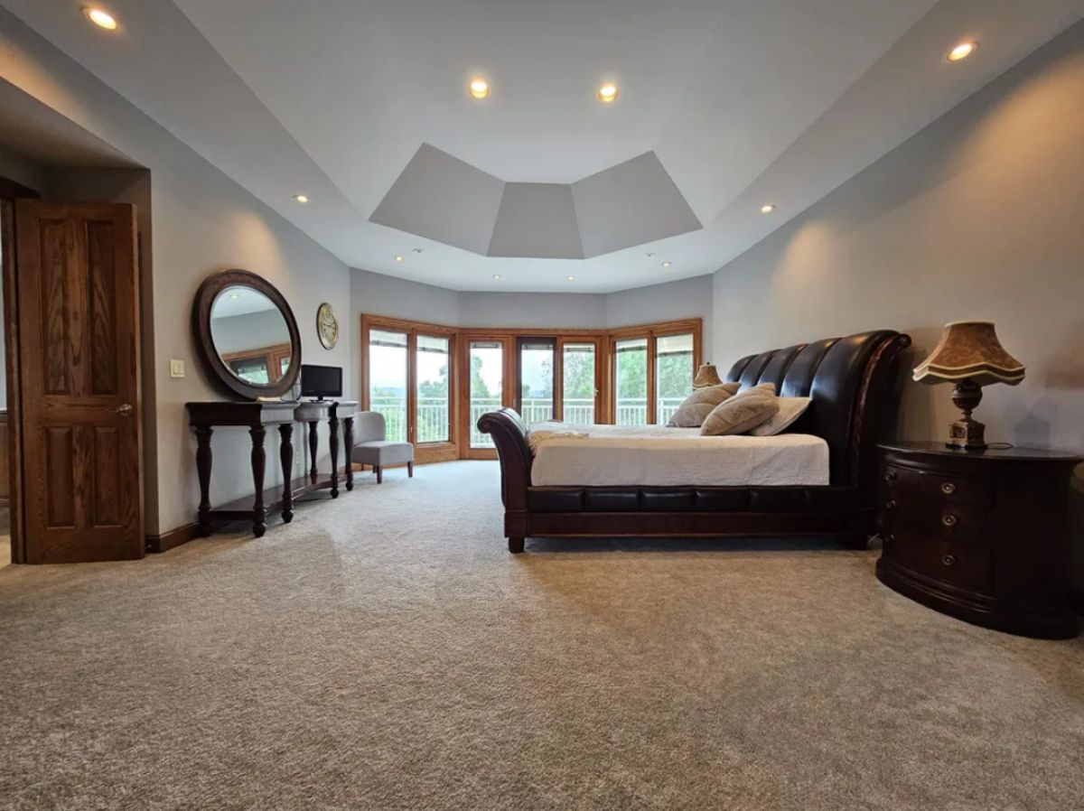 Bedroom with carpet flooring, custom lighting, and large glass doors.