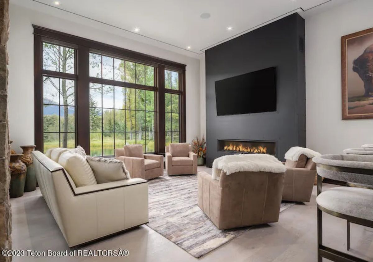 Media room with couches, a TV, and a fireplace.