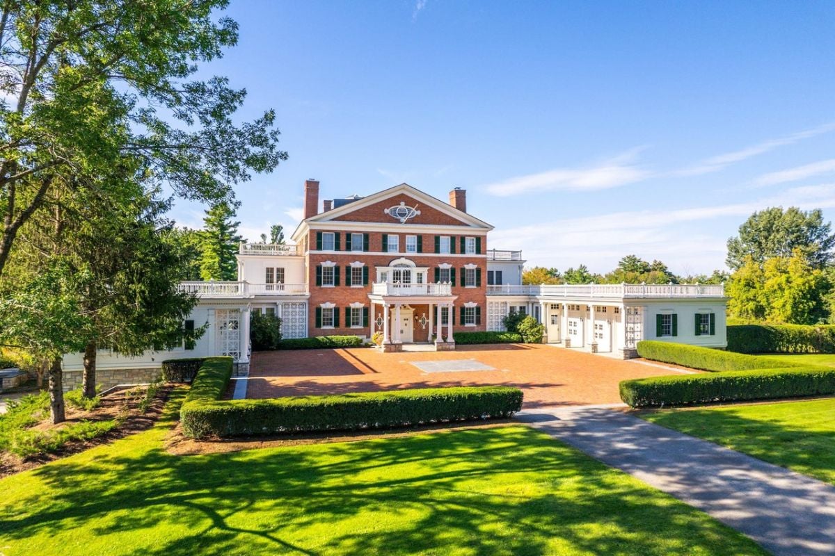 Front view of the mansion with a large green lawn.