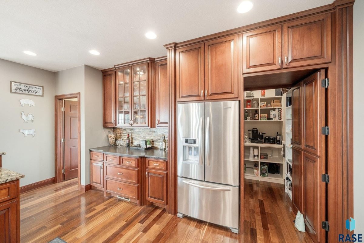 Kitchen with wood flooring, custom cabinets, pantry and custom lights.
