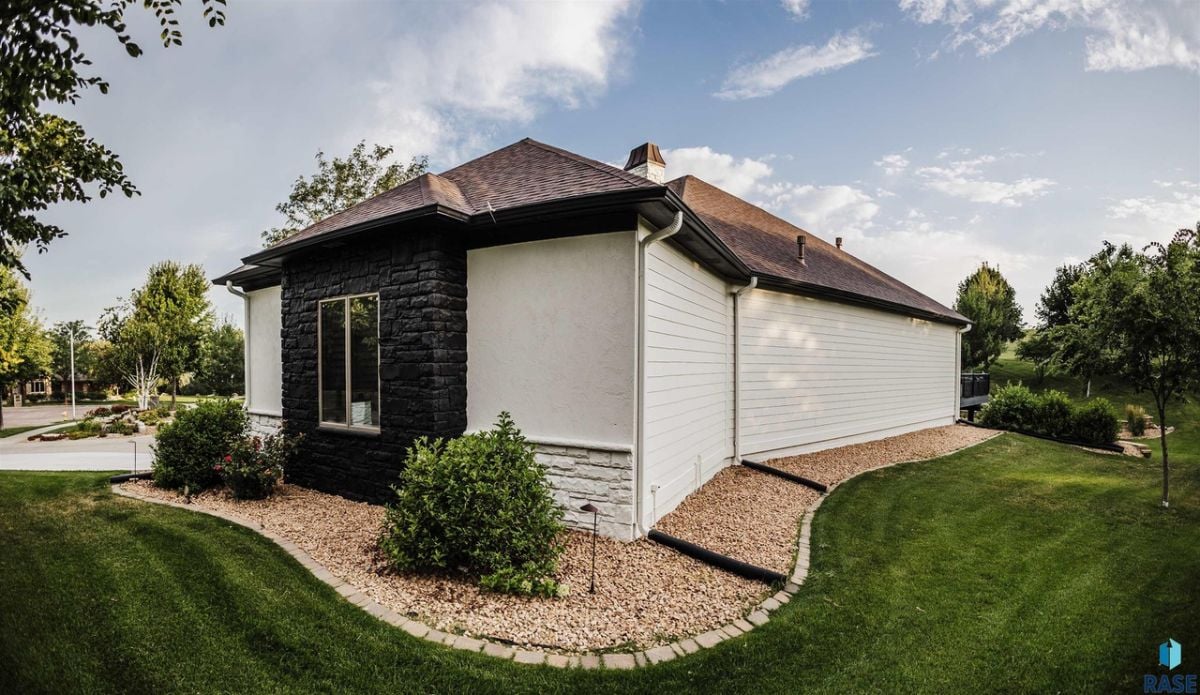Side view of the property with a large green lawn.