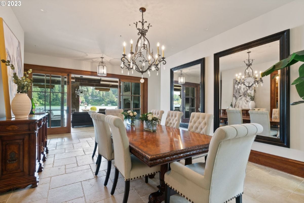 Dining room with a large table, chairs and chandelier.