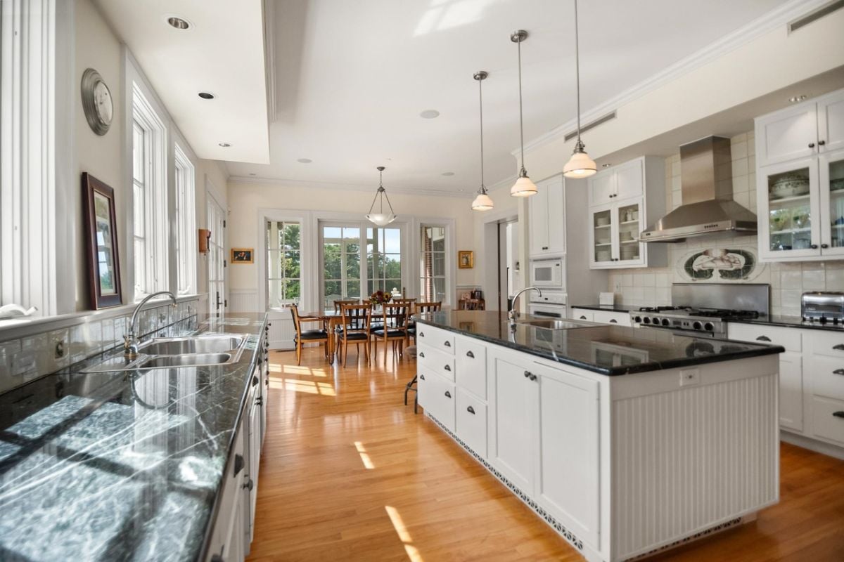 Kitchen with a large center island, granite countertops, custom lights and custom cabinets.