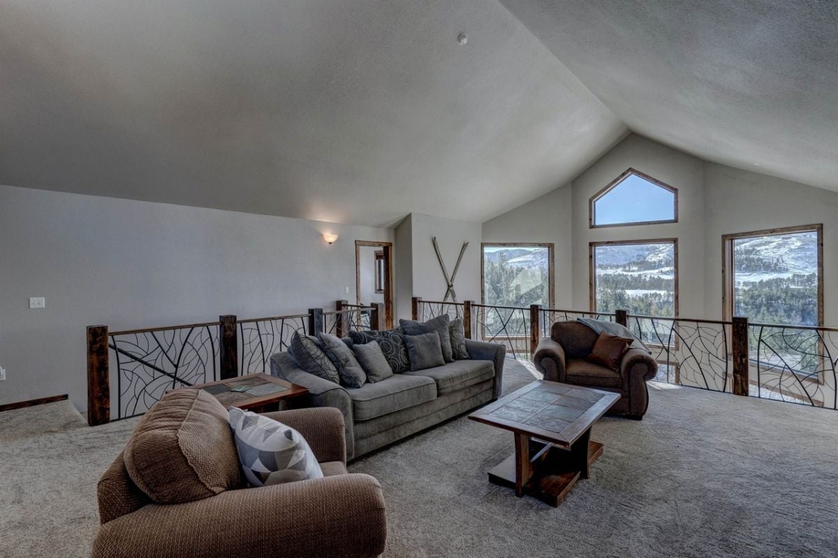 Living room with couches, table and carpet flooring.