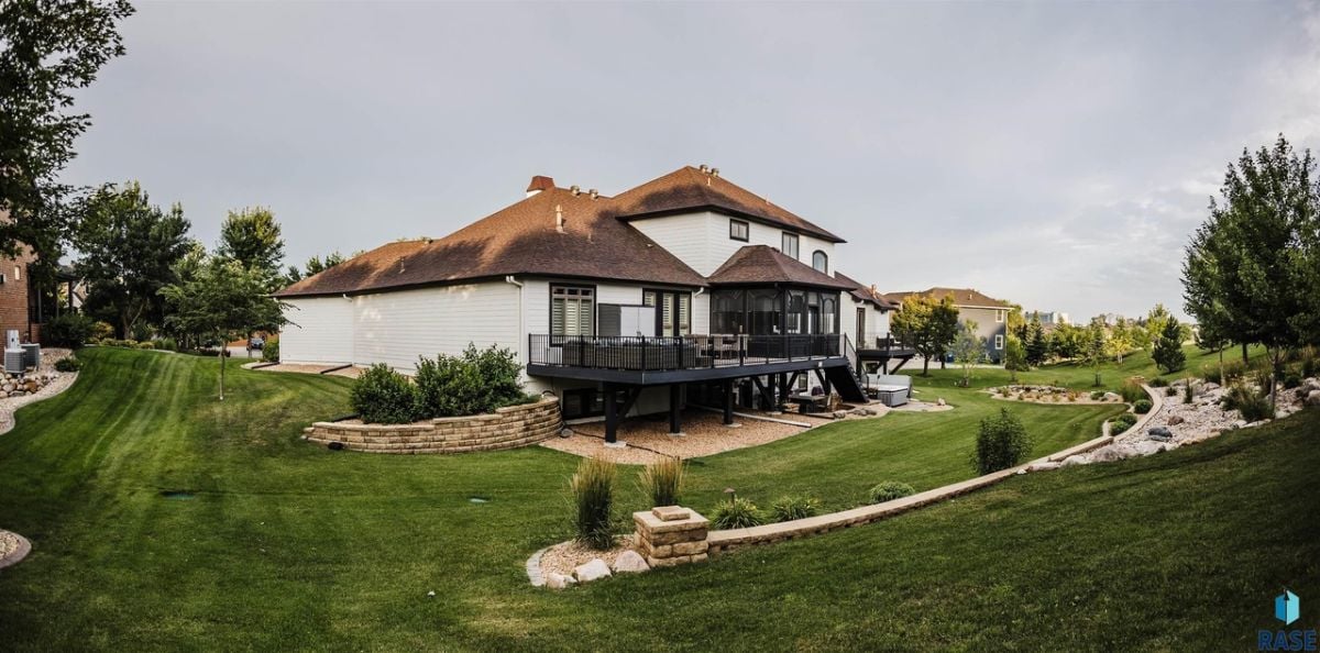 Rear view of the property with a large green lawn.