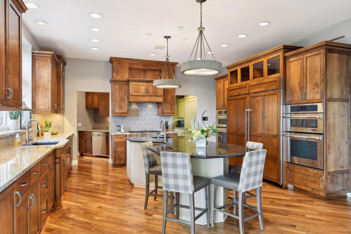 Kitchen with a breakfast area, custom lights, stainless steel appliances and custom cabinets.