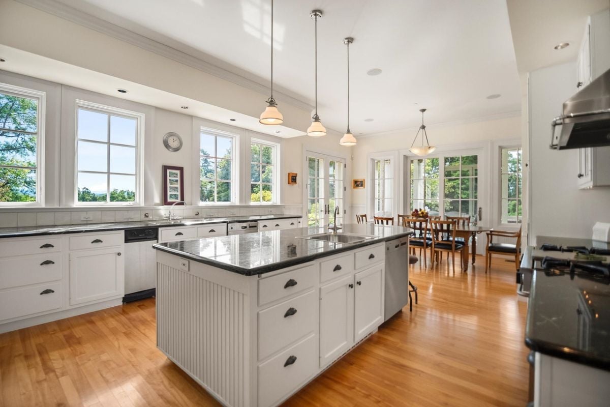 Kitchen with a large center island, granite countertops, custom lights and custom cabinets.