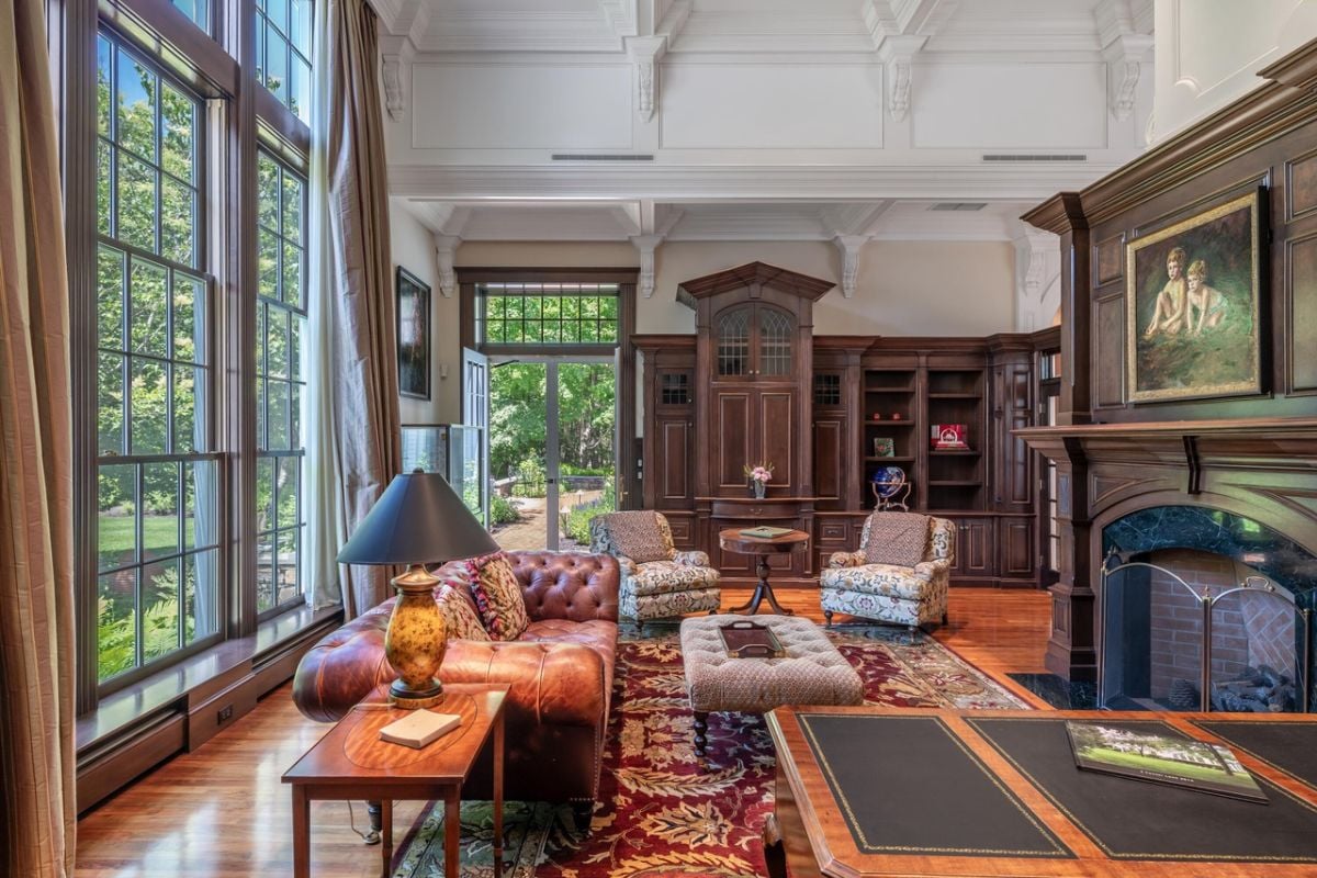 Living room with couches,, glass door, glass walls, fireplace and a rug.