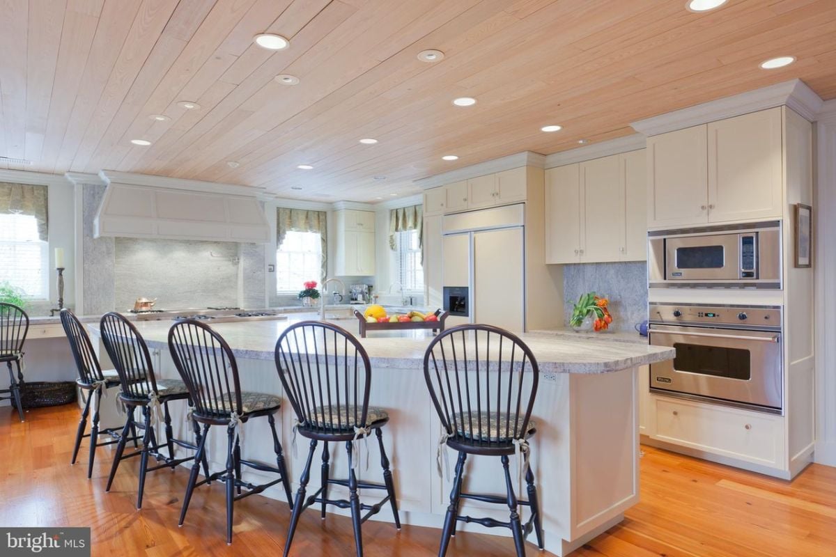 Kitchen with a large island, custom lights, custom cabinets and high-end appliances.